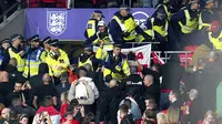 Bentrokan suporter Hungaria dengan polisi saat dimulainya laga Kualifikasi Piala Dunia 2022 melawan Inggris di Stadion Wembley, Rabu (13/10/2021) dini hari WIB. Bentrokan terjadi saat polisi berusaha menangkap penonton yang melakukan pelecehan rasial terhadap petugas stadion. (Nick Potts/PA via AP)