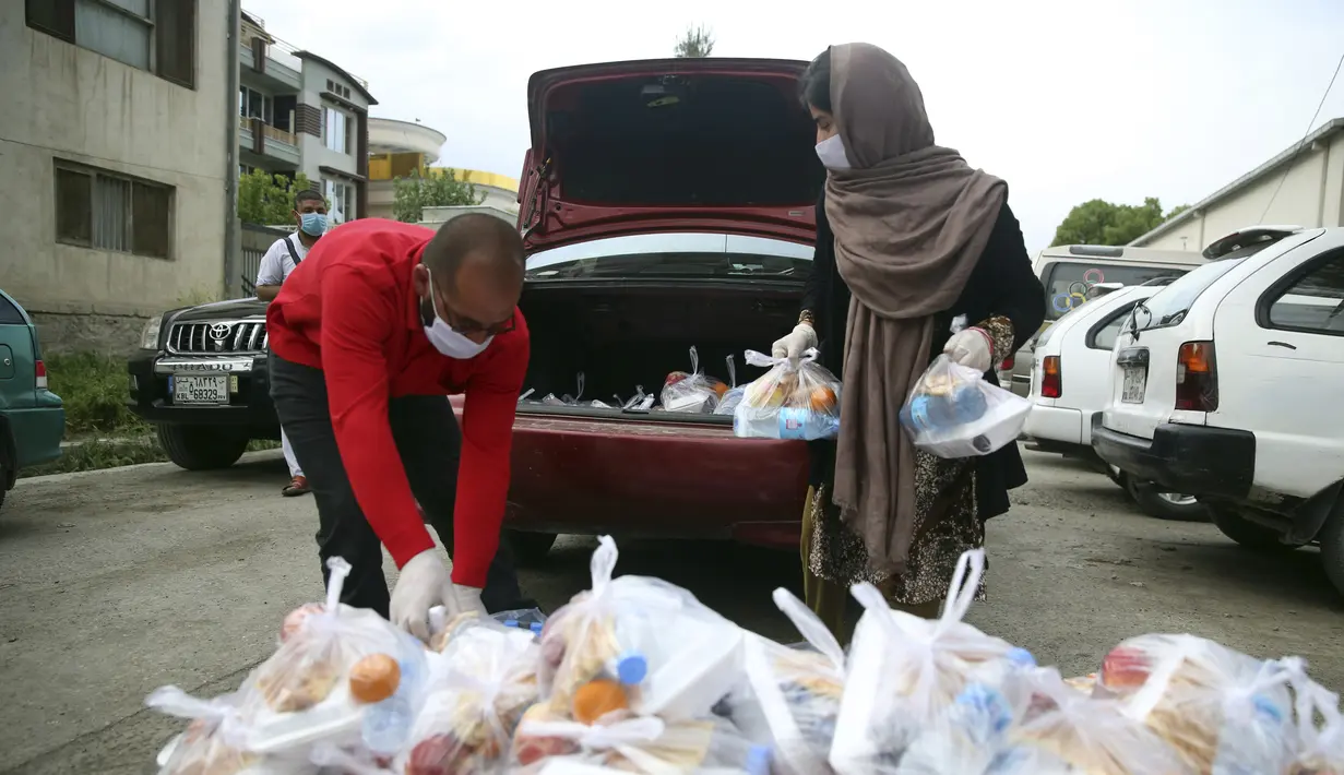 Sukarelawan menyiapkan makanan berbuka puasa gratis untuk orang-orang yang membutuhkan selama bulan puasa suci Ramadan di Kabul, Afghanistan, Kamis (7/5/2020). Muslim di seluruh dunia melewati Ramadan tahun ini di tengah pandemi virus corona COVID-19 dan PHK. (AP Photo/Rahmat Gul)