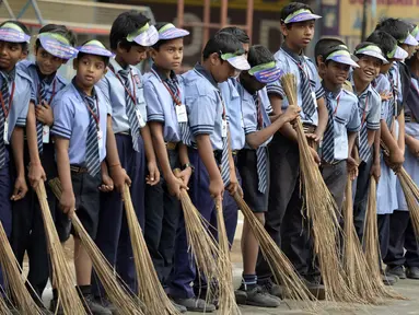 Sejumlah pelajar India membawa sapu saat mengambil bagian dalam 'Swachh Bharat Abhiyan' atau kampanye kebersihan di Hyderabad (12/2). Kampanye ini bertujuan untuk membersihkan jalanan dan infrastruktur di kota-kota India. (AFP Photo/Noah Seelam)