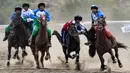 Penunggang kuda dari Uzbekistan (Biru) dan Rusia (Merah) memainkan olahraga tradisional Asia Tengah Kok Boru (Serigala Abu-Abu) atau Buzkashi (Mencengkeram Kambing) saat Piala Dunia Kok Boru di Cholpon-Ata dekat Danau Issyk-Kule, sekitar 250 Km sebelah timur Bishkek, 14 Agustus 2023. Pemain berkuda bersaing untuk mendapatkan poin dengan melempar boneka kulit domba ke dalam sumur. (VYACHESLAV OSELEDKO/AFP)