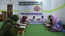 Anggota komunitas transgender belajar membaca Alquran di dalam Madrasah Dawatul Islam Tritio Linger untuk jenis kelamin ketiga, di Dhaka, Bangladesh, Selasa (17/11/2020). Pendirian madrasah ini dianggap salah satu upaya Bangladesh untuk membuat hidup kaum LGBT lebih mudah. (Munir Uz zaman/AFP)