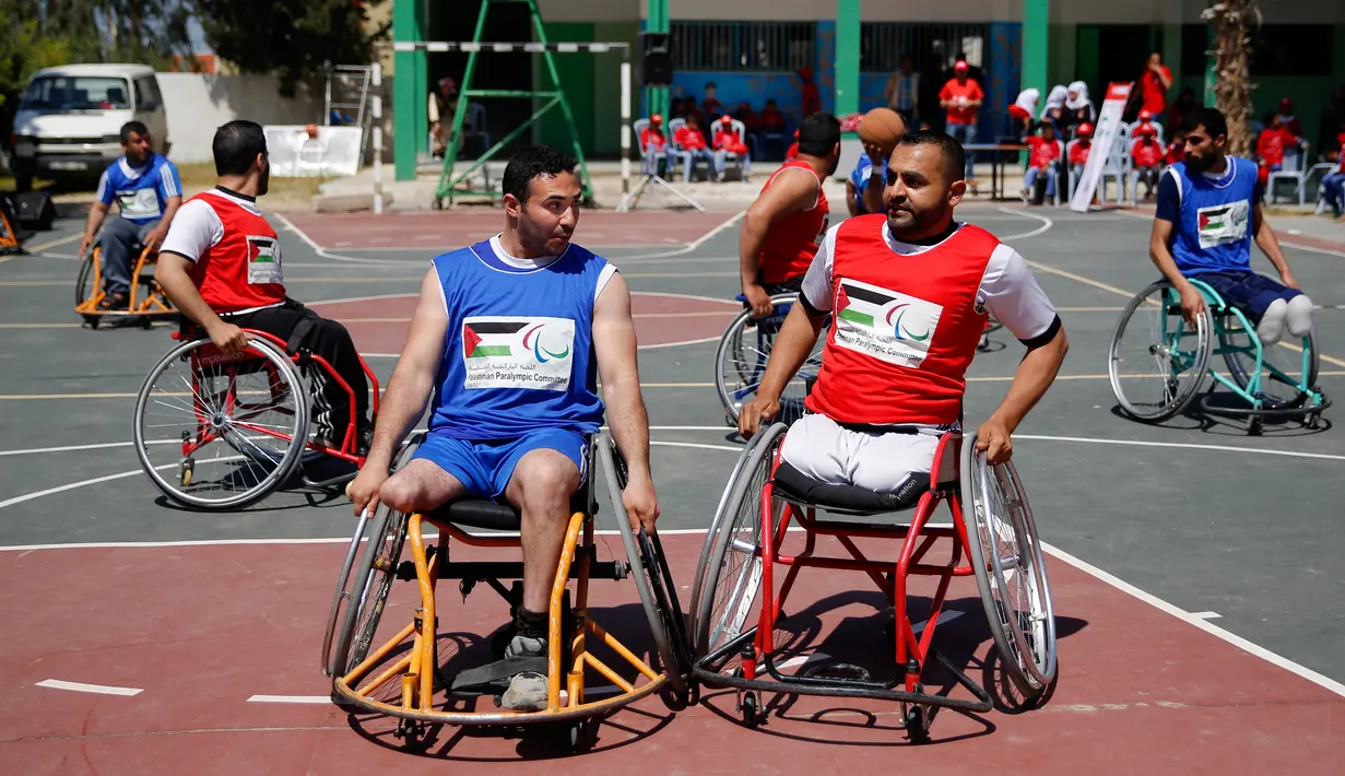 Sejumlah pria yang menggunakan kursi roda bermain basket di lapangan sekolah milik pemerintah di Kota Gaza (4/4). Mereka adalah warga Palestina yang telah kehilangan anggota badannya akibat perang antar kelompok Hamas dan Israel. (AP Photo/Hatem Moussa)
