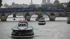 Kapal yang membawa kontingan Indonesia menyusuri sungai Seine saat pembukaan Olimpiade Paris 2024 di Paris, Prancis, Kamis (26/7/2024). (SEBASTIEN BOZON / AFP)