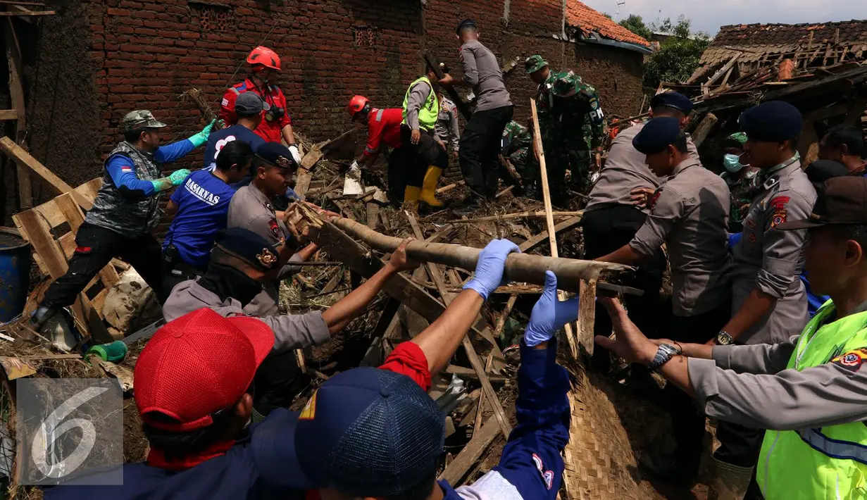 Petugas saat menyisir reruntuhan bangunan rumah akibat banjir bandang di Kampung Bojong Sudika, Cimacan, Garut, Jumat (23/9). Hingga saat ini tercatat 23 warga yang hilang akibat kejadian banjir bandang yang menimpa Kota Garut. (Liputan6.com/Johan Tallo)