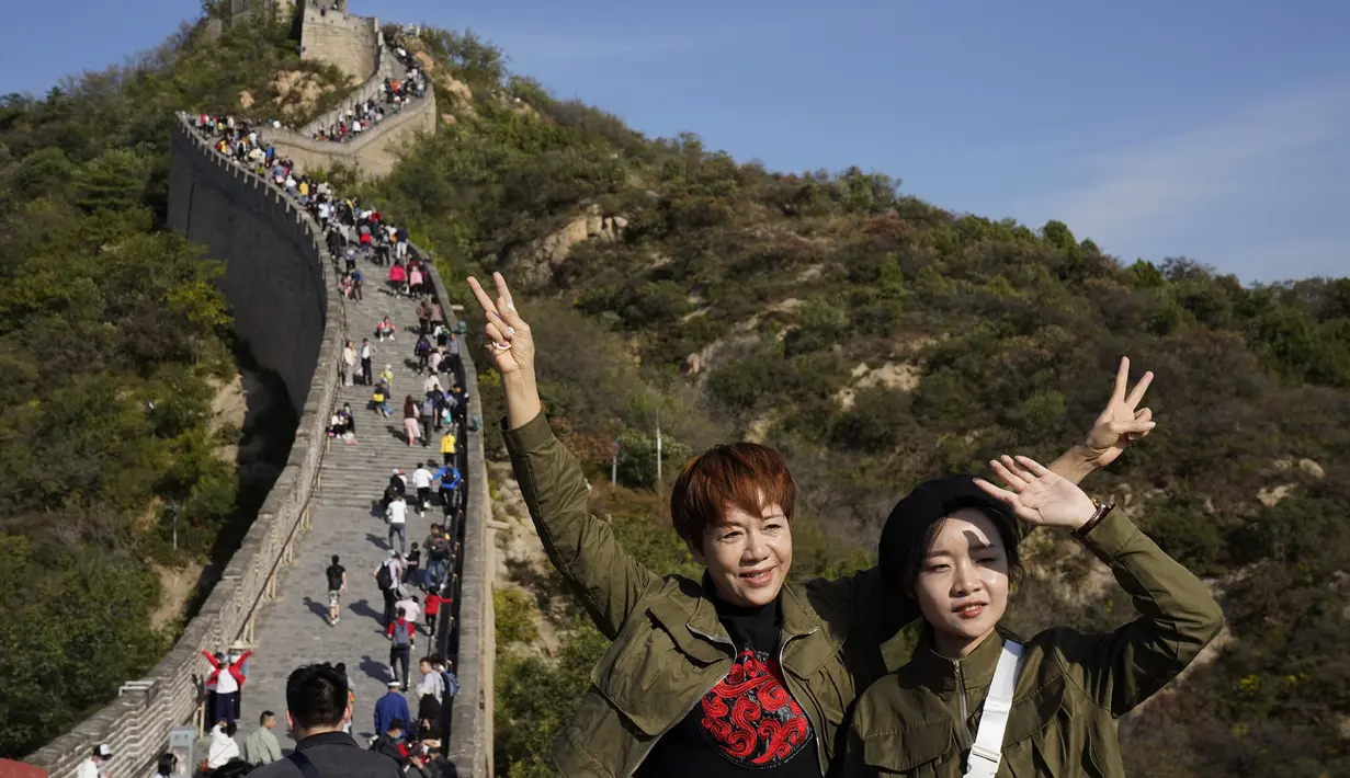 Wisatawan berpose di sepanjang hamparan Tembok Besar Badaling di pinggiran Beijing (6/10/2020). 425 juta turis China melakukan perjalanan domestik di paruh pertama delapan hari libur Hari Nasional, menghasilkan $ 45,9 miliar pendapatan pariwisata. (AP Photo/Ng Han Guan)