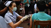Seorang perawat menyuntikkan vaksin Covid-19 CoronaVac dari Sinovac di Institut Penyakit Menular Bamrasnaradura di Bangkok, Thailand, Minggu (28/2/2021). Tenaga medis dan relawan kesehatan menjadi golongan pertama yang menerima vaksin Covid-19 tersebut. (Lillian SUWANRUMPHA/AFP)