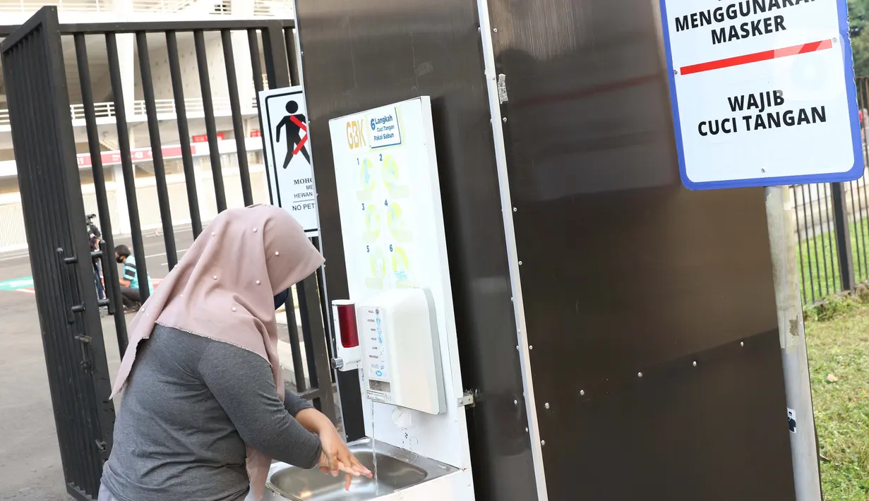 Warga mencuci tangan sebelum masuk ke area Stadion Utama Gelora Bung Karno, Jakarta, Sabtu (6/6/2020). SUGBK dibuka kembali untuk kegiatan olahraga masyarakat dengan menerapkan protokol kesehatan pasca keputusan Pemprov DKI Jakarta menerapkan PSBB transisi. (Liputan6.com/Helmi Fithriansyah)