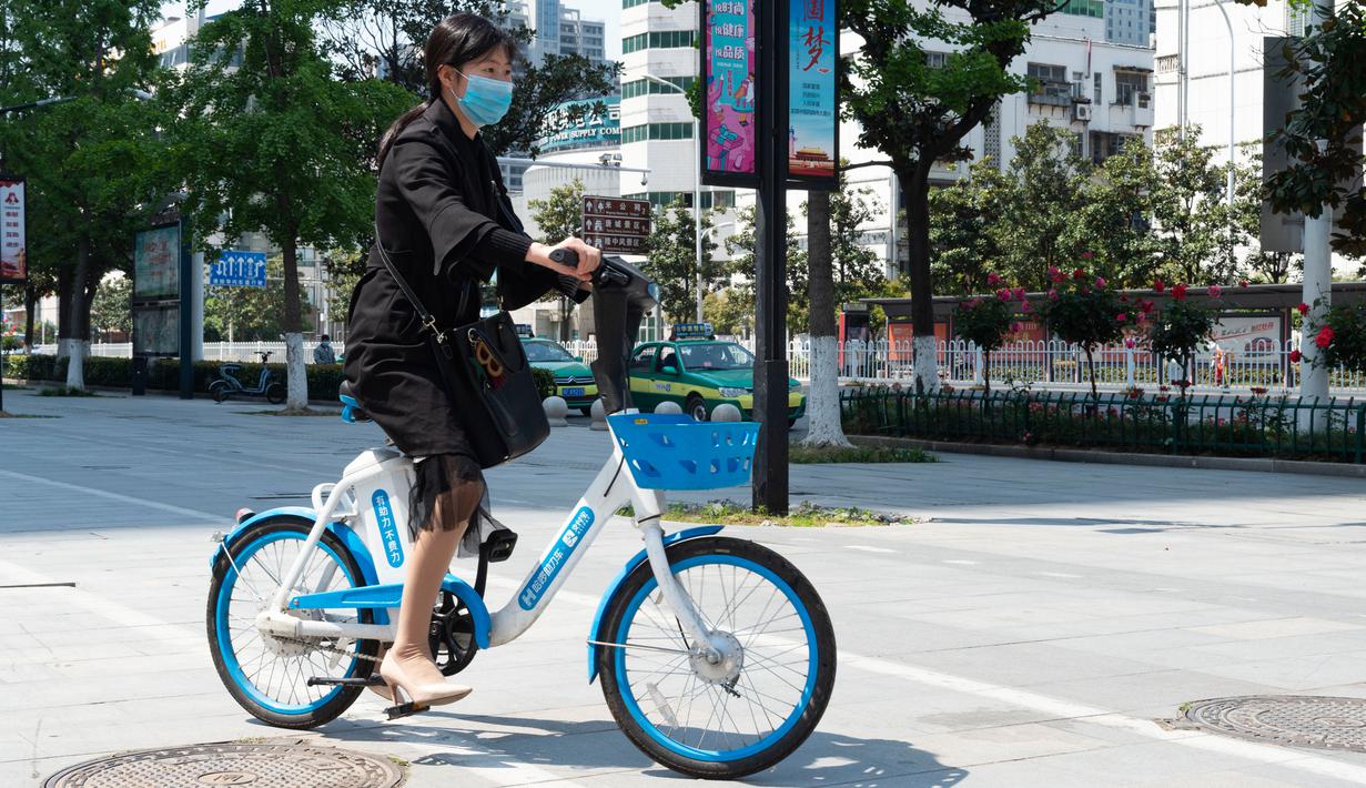 Warga mengendarai sepeda listrik untuk layanan berbagi kendaraan di Distrik Fancheng di Kota Xiangyang, Provinsi Hubei, China tengah (24/4/2020). Seiring meredanya pandemi COVID-19, perusahaan-perusahaan layanan berbagi sepeda di kota tersebut bertahap memulai kembali bisnisnya. (Xinhua/Xie Jianfei)