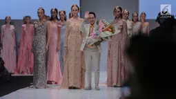 Desainer Barli Asmara bersama para model menyapa pengunjung di ajang Jakarta Fashion Week 2018 di Senayan City, Jakarta, Senin (23/10). Desainer Barli Asmara mengusung tema Jambi Kain Negeriku. (Liputan6.com/Faizal Fanani)
