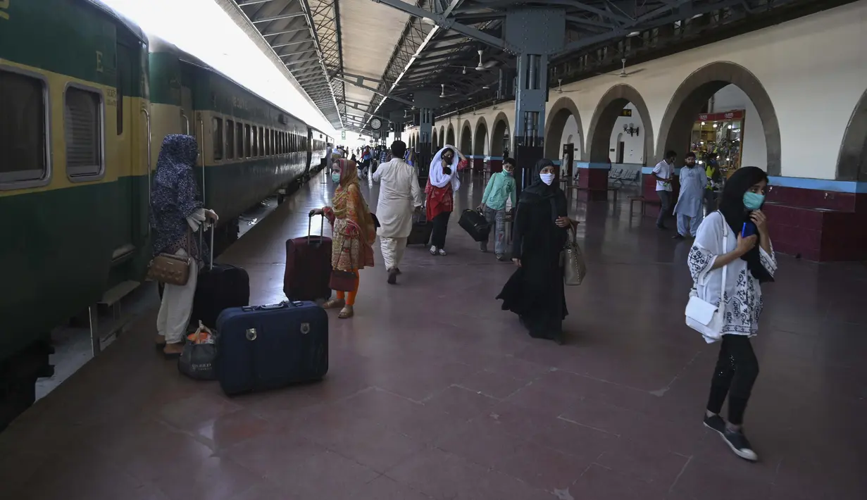Penumpang mengenakan masker saat menunggu kereta di Stasiun Rawalpindi, Pakistan, Rabu (20/5/2020). Pakistan kembali membuka layanan kereta setelah pemerintah melonggarkan kebijakan lockdown jelang Idul Fitri. (Aamir QURESHI/AFP)