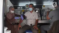 Petugas Dinas Kesehatan Kota Bogor melakukan skrining kesehatan kepada calon penerima vaksin Covid-19 dosis ketiga (booster) di mobil vaksinasi keliling, Terminal Penumpang Tipe A Baranangsiang, Kota Bogor, Sabtu (23/4/2022). Pemkot Bogor menyediakan sentra vaksinasi Covid-19 dosis booster untuk pemudik Lebaran 2022 di terminal tersebut sebagai salah satu upaya pemenuhan syarat perjalanan sekaligus untuk menekan laju penularan Covid-19 di tengah tingginya mobilitas masyarakat. (merdeka.com/Arie Basuki)