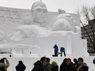 Sejumlah pengunjung melihat patung es Star Wars selama hari pembukaan Festival Salju Sapporo di Sapporo, Jepang (4/2). Festival Salju Sapporo dilangsungkan selama seminggu pada awal bulan Februari. (AFP Photo/Jiji Press)