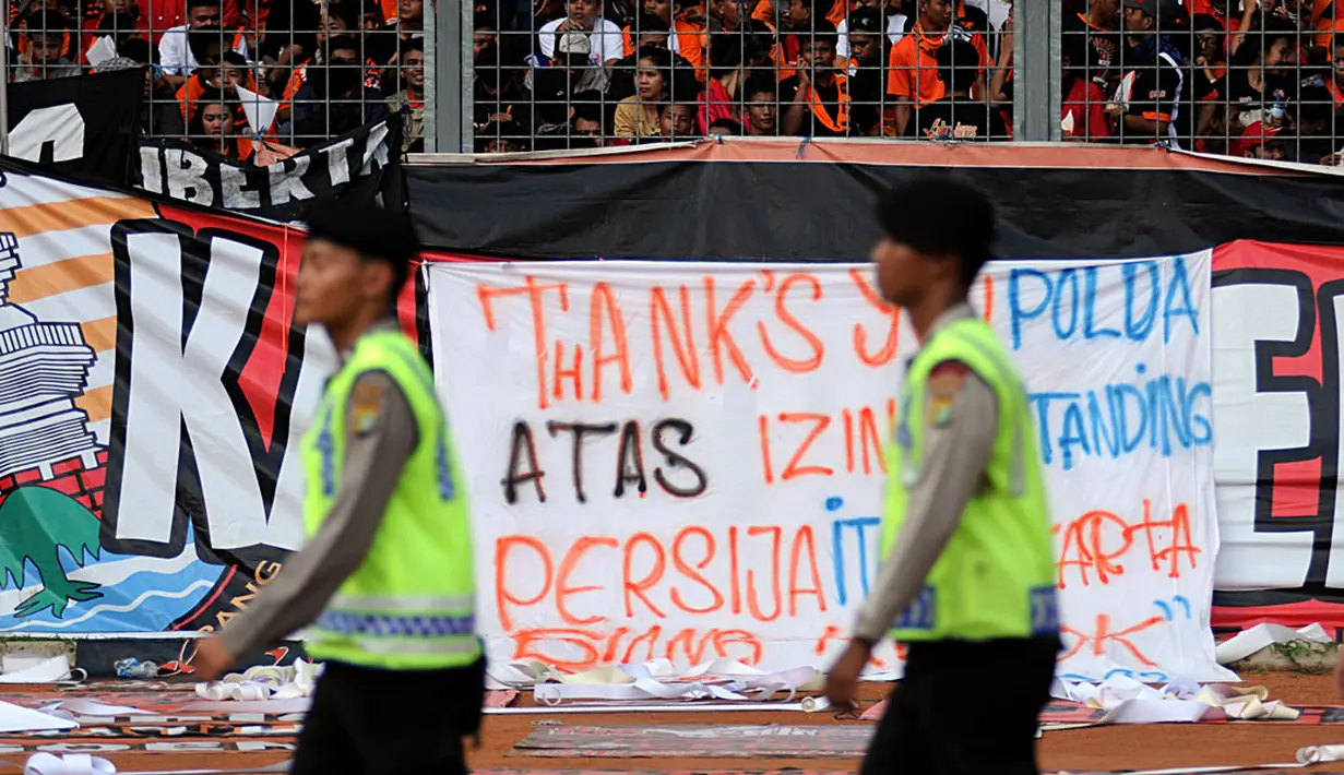 Jakmania memasang kain yang bertuliskan ucapan terima kasih kepada pihak Polda Metro Jaya yang memberikan ijin bertanding buat Persija Jakarta di Stadion GBK, (10/8/2014). (Liputan6.com/Helmi Fithriansyah)