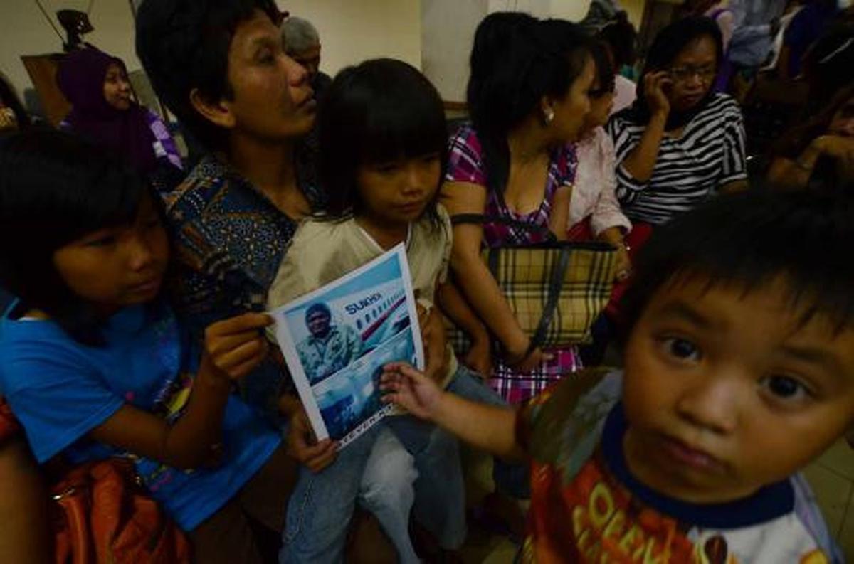 Putri dari Steven Kamagi memegang foto ayahnya yang ikut dalam penerba 