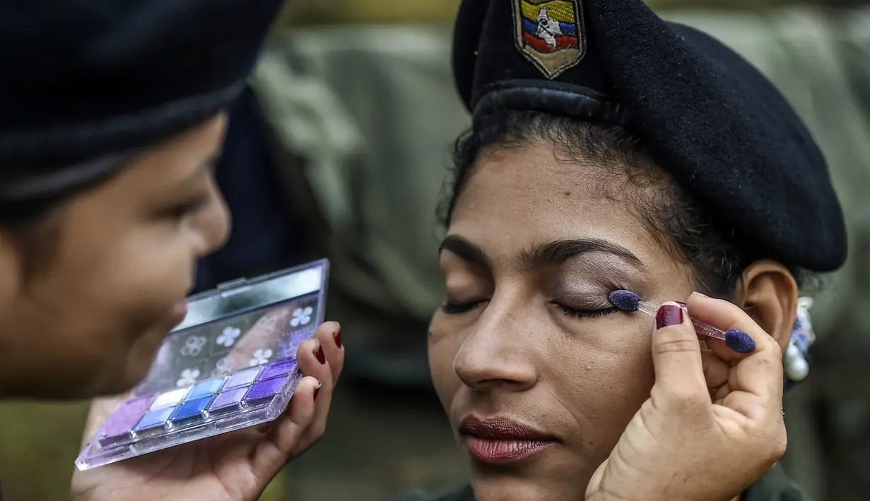 Seorang gerilyawati FARC sedang dirias oleh kawannya di kamp Magdalena Medio, Kolombia (15/3/2016). Gerilyawati FARC dikenal lebih sadis terhadap musuh daripada pasukan gerilyawan. (AFP Photo/Luis Acosta)