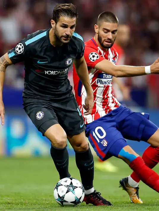 Gelandang Chelsea, Cesc Fabregas membawa bola dari kawalan pemain Atletico Madrid, Yannick Carrasco pada grup C Liga Champions di stadion Wanda Metropolitano, Spanyol, (27/9). Chelsea menang tipis 2-1 atas Atletico Madrid. (AP Photo/Francisco Seco)