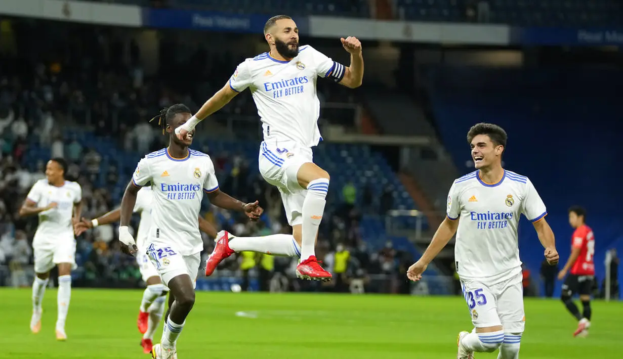 Penyerang Real Madrid Karim Benzema (kiri) berselebrasi setelah mencetak gol pertama untuk timnya ke gawang Mallorca pada jornada keenam La Liga Spanyol di Santiago Bernabeu, Kamis (23/9/2021) dini hari WIB. Real Madrid berpesta gol usai melibas Real Mallorca 6-1. (AP Photo/Manu Fernandez)