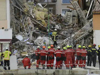 Petugas pemadam kebakaran mencari korban dari puing-puing bangunan yang runtuh di Sanary-sur-Mer, Prancis, 7 Desember 2021. Satu orang tewas dan dua lainnya masih dinyatakan hilang setelah gedung apartemen tiga lantai runtuh akibat ledakan gas. (NICOLAS TUCAT/AFP)