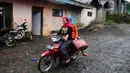 Dua orang warga desa kawasan zona merah Gunung Slamet tampak mengendarai motor untuk pergi ke pasar. (Liputan6.com/Andrian M Tunay)