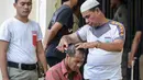 Seorang anak Punk dicukur rambutnya oleh petugas kepolisian di Banda Aceh (9/1). Indonesia merupakan negara yang memiliki populasi punk terbesar di dunia. (AFP Photo/Chaideer Mahyuddin)