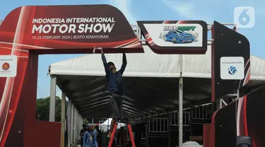 Pekerja menyelesaikan pembuatan stand pameran Indonesia International Motor Show 2024 di Jakarta International Expo (JIexpo), Jakarta Senin (12/2/2024). (merdeka.com/Imam Buhori)