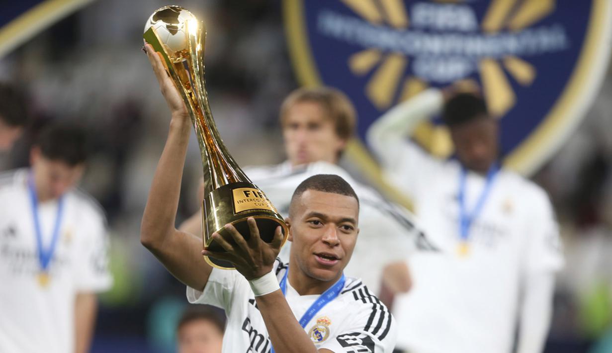 Pemain Real Madrid, Kylian Mbappe, mengangkat trofi setelah menjuarai FIFA Intercontinental Cup 2024. (AP Photo/Hussein Sayed)