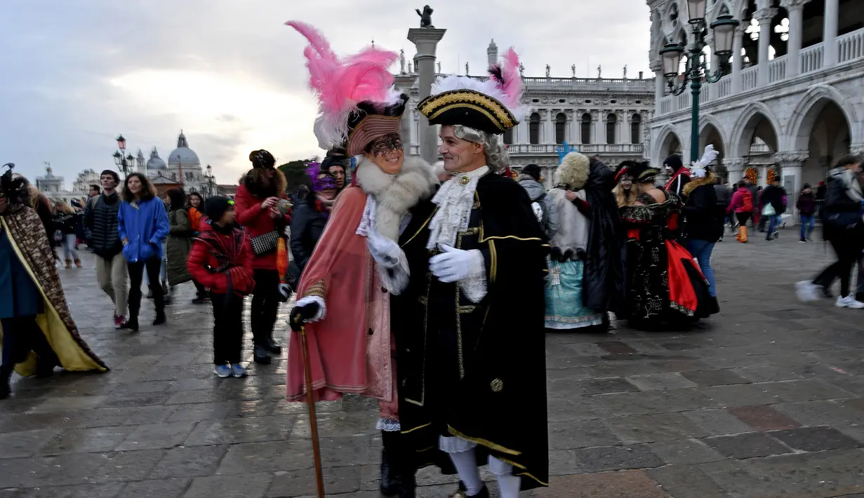 Sejumlah peserta mengenakan kostum dan topeng menari saat mengikuti Karnaval Venesia di Italia (27/1). Karnaval ini dimulai 40 hari sebelum hari paskah dan berakhir pada Mardi Gras, atau hari Rabu abu. (AFP Photo/Filippo Monteforte)