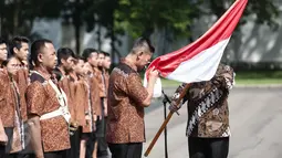 Seorang kontingen Olimpiade mencium bendera dalam pelepasan Tim Indonesia menuju Olimpiade 2016 di Brasil, di halaman Istana Merdeka, Jakarta, Rabu (22/6). Sebanyak 26 atlet akan bertarung pada pesta olah raga tingkat dunia. (Liputan6.com/Faizal Fanani)