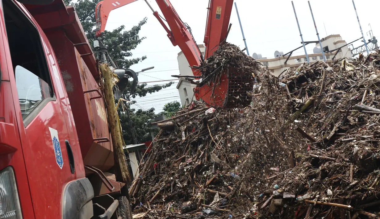 Alat berat mengangkat sampah yang menumpuk di Pintu Air Manggarai, Jakarta, Jumat (26/4). Sampah yang didominasi potongan bambu dan botol plastik kembali memenuhi Pintu Air Manggarai akibat curah hujan yang tinggi di kawasan Bogor dan sekitarnya, Kamis (25/4). (Liputan6.com/Helmi Fithriansyah)