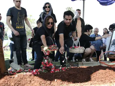 Musisi Indra Lesmana bersama Mira Lesmana menaburkan bunga di pemakamanya ibunya, Nien Lesmana di TPU Tanah Kusir, Jakarta, Rabu (28/6). (Liputan6.com/Herman Zakharia)