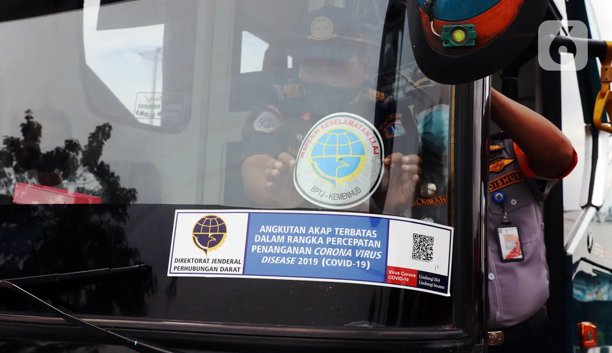 Petugas Dinas Perhubungan menempelkan stiker pada kaca saat menginspeksi keselamatan bus di Terminal Kalideres, Jakarta, Selasa (22/12/2020). Inspeksi dilakukan untuk memastikan bus AKAP layak jalan untuk mengantar para pemudik jelang libur Natal dan Tahun Baru 2021. (Liputan6.com/Angga Yuniar)