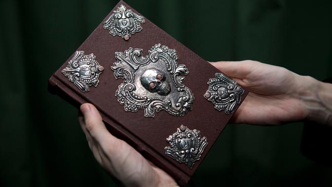 Pekerja memperlihatkan buku langka yang ditulis tangan dan digambar oleh penulis 'Harry Potter' J.K. Rowling berjudul 'The Tales of Beedle the Bard' di rumah lelang di London, 9 Desember 2016. Buku itu terjual seharga Rp6,2 miliar. (Justin TALLIS/AFP)