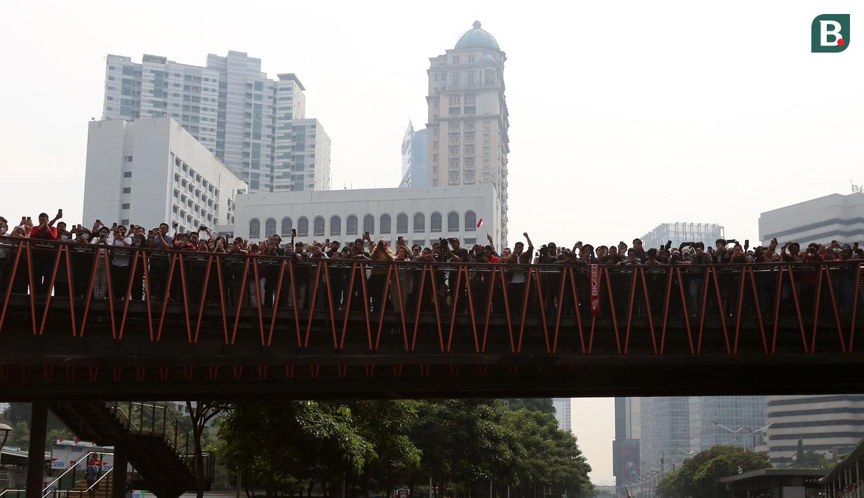 Sejumlah masyarakat saat menyambut Timnas Indonesia U-22 dan kontingen Indonesia untuk SEA Games 2023 saat pawai Kira87uara yang berlangsung dari Kemenpora hingga GBK, Jakarta, Jumat (19/05/2023). (Bola.com/Bagasakra Lazuardi)