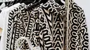 Salah satu foto menunjukkan Kim Kardashian berbaring di depan tiupan metalik, mengenakan korset bustier, rok midi berbahan kulit, tas karung yang serasi dengan sarung tangan berwarna hitam dengan bintik-bintik putih, dan sepatu boot Kiki setinggi satu inci yang khas Marc Jacobs. [Foto: Document/Marc Jacobs]