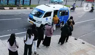 Para calon penumpang antre menunggu giliran untuk naik transportasi layanan angkutan umum JakLingko di Stasiun Klender Baru, Pondok Kopi, Jakarta, Senin (19/2/2024). (merdeka.com/Imam Buhori)