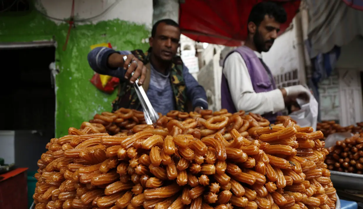 Para pedagang menata penganan manis untuk dijual saat bulan suci Ramadan di sebuah pasar di Sanaa, Yaman, Sabtu (25/4/2020). (Xinhua/Mohammed Mohammed)