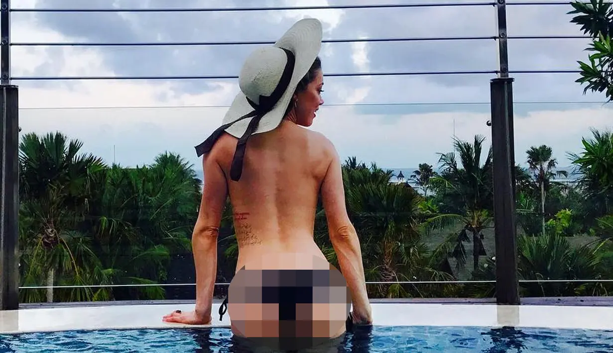 Aktris Amber Heard berpose di sebuah kolam renang di Bali, Indonesia. Mantan istri aktor Johnny Depp tampil topless saat berlibur di Pulau Dewata tersebut. (Instagram/@amberheard)