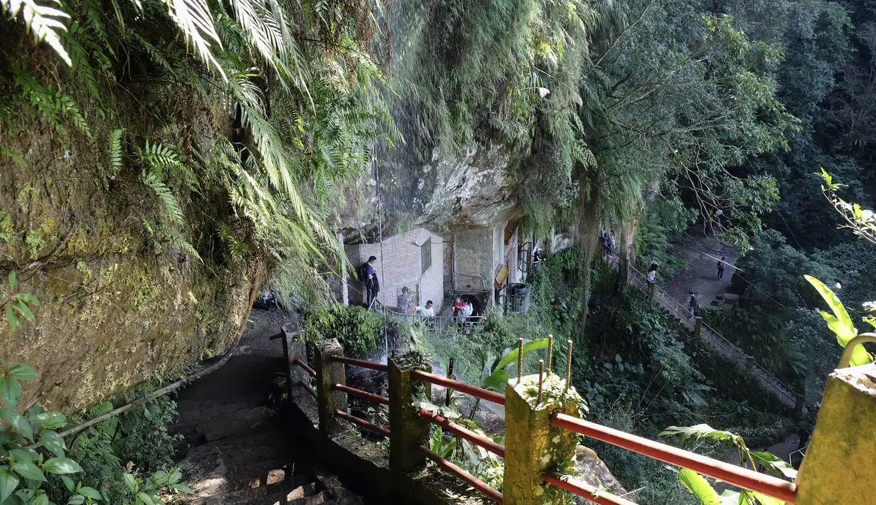 Sejumlah turis saat mengunjungi Kuil Tao di gua Gunung Yinhe di distrik Xindian, Kota Taipei Baru, Taiwan (29/12/2019). Kuil Tao ini menawarkan keindahan alamnya yang sejuk karena berada di pegunungan Yinhe di distrik Xindian di Kota Taipei Baru. (AFP Photo/Sam Yeh)