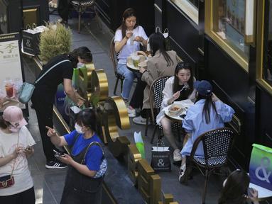 Pengunjung mengenakan masker mengobrol di restoran yang dibuka kembali di pusat perbelanjaan di Beijing, Senin (6/6/2022). Pengunjung kembali ke restoran di sebagian besar Beijing untuk pertama kalinya dalam lebih dari sebulan sebagai pihak berwenang lebih lanjut melonggarkan pembatasan terkait pandemi wabah COVID-19. (AP Photo/Andy Wong)