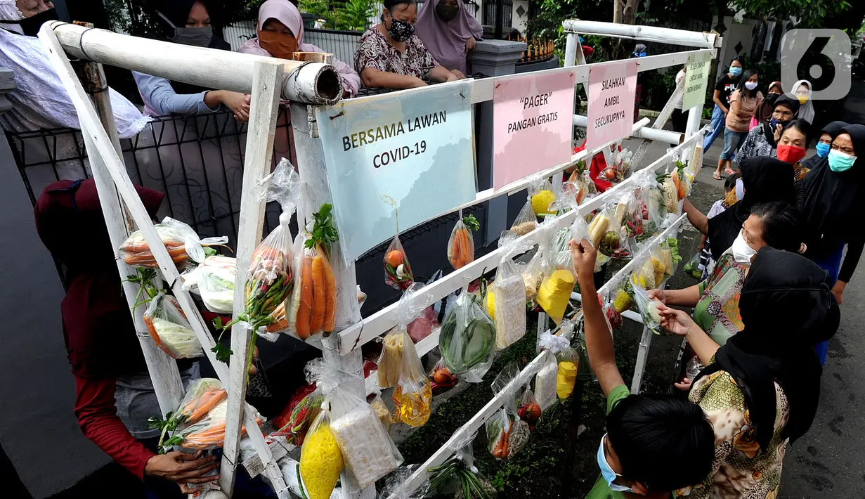 Warga terdampak Covid-19 mengambil bahan pangan gratis di Kompleks Bumi Menteng Asri, Rt 01/18, Kelurahan Menteng, Bogor, Kamis (21/5/2020).  Bahan pangan tersebut disediakan secara swadaya warga setempat dan sudah berjalan selama Bulan Ramadan. (merdeka.com/Arie Basuki)
