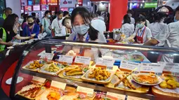 Seorang peserta pameran menyiapkan produk daging dalam Pameran Industri Daging Internasional China ke-18 di Qingdao, Provinsi Shandong, China, 10 September 2020. (Xinhua/Li Ziheng)