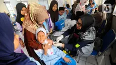 Petugas Puskesmas Cinere saat melakukan pemberian vaksin HPV Nusagard  di SDI Al-Hidayah, Depok, Jawa Barat, Jumat(11/8/2023). (merdeka.com/Arie Basuki)