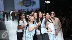 Artis sekaligus Desainer Luna Maya berselfie bersama para artis saat membawakan busana bertema midnight bloom di Jakarta Fashion Week (JFW) 2016, Senayan city, Jakarta (25/10/2015). (Liputan6.com/Herman Zakharia)