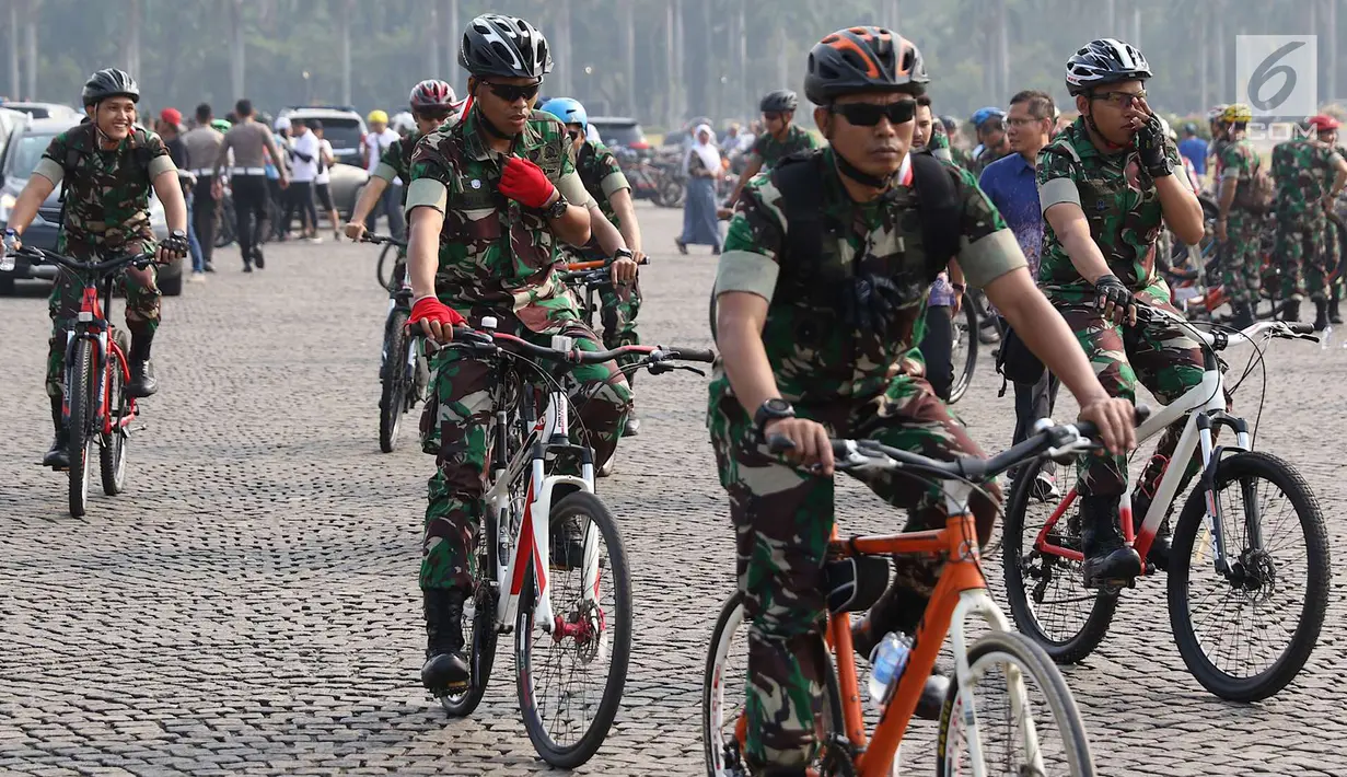 Prajurit TNI mengikuti kegiatan Sepeda Nusantara 2018 yang diselenggarakan Polri di kawasan Monas, Jakarta, Kamis (9/8). Rute kegiatan ini mengambil start dari Gedung Perguruan Tinggi Ilmu Kepolisian (PTIK) menuju Monas. (Liputan6.com/Immanuel Antonius)