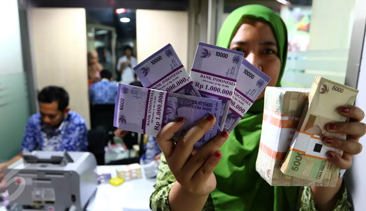 Seorang karyawan menunjukkan uang pecahan rupiah yang telah ditukar di mobil kas Bank Indonesia (BI) di Lantai 7 SCTV Tower, Jakarta, Jumat (24/6). BI membawa uang Rp 700 juta untuk ditukarkan oleh para karyawan EMTEK Group. (Liputan6.com/Fery Pradolo)