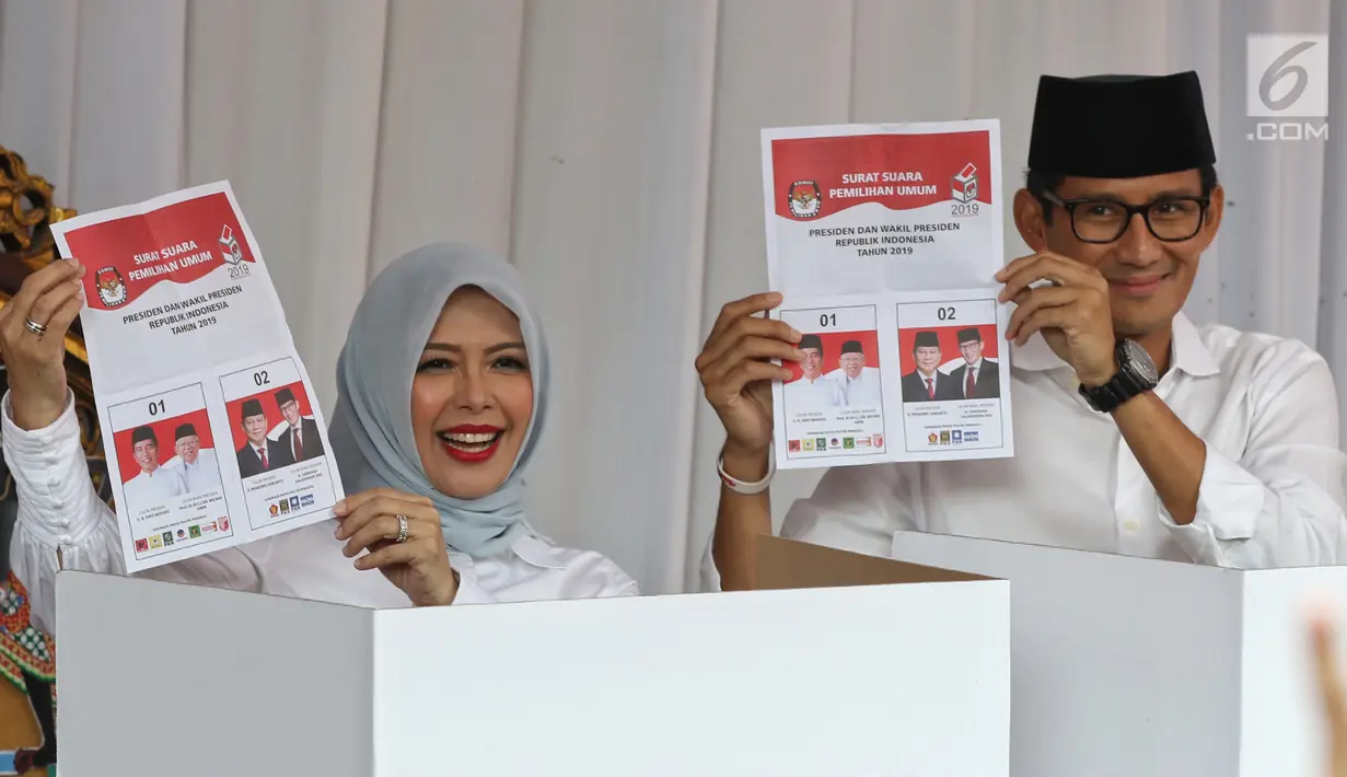 Calon Wakil Presiden nomor urut 02 Sandiaga Uno bersama istri Nur Asia Uno (kiri) menunjukan surat suara sebelum mencoblosnya di TPS 002 Selong, Kebayoran Baru, Jakarta Selatan, Rabu (17/4). Sandiaga Uno dan Nur Asia menggunakan hak pilihnya dalam Pemilu 2019. (Liputan6.com/Johan Tallo)