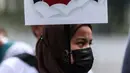 Aktivis yang tergabung dalam Serikat Buruh Migran Indonesia (SBMI) melakukan aksi damai di Kawasan Monas, Jakarta Pusat, Minggu (13/3/2022). Aksi ini merupakan bentuk protes kepada pemerintah dan perusahaan kerena telah bertindak tidak adil kepada para pekerja perempuan. (Liputan6.com/Johan Tallo)