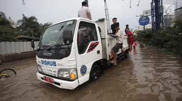 Petugas Dinas Perhubungan (Dishub) mengevakuasi karyawan dan warga yang terjebak banjir di Jalan Boulevard Raya, Kelapa Gading, Jakarta, Kamis (15/2). Banjir diakibatkan guyuran hujan sejak pagi hingga sore. (Liputan6.com/Arya Manggala)