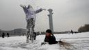 Anak-anak bermain salju di kanal beku di Taman Olimpiade Beijing di Beijing pada 20 Januari 2022. Ibu Kota China diselimuti salju pada Kamis, saat hitungan mundur menuju dua minggu Olimpiade Musim Dingin Beijing 2022 dimulai. (Noel Celis / AFP)