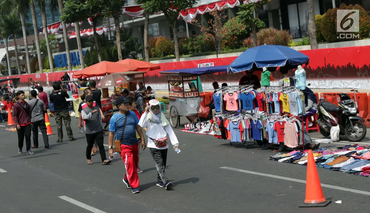 Pedagang kaki lima (PKL) menggelar dagangannya di Jalan Jenderal Sudirman saat Hari Bebas Kendaraan, Jakarta, Minggu (25/8/2019). Para PKL ini menggelar dagangannya terlalu menjorok ke tengah jalan sehingga mengganggu kenyamanan warga yang berolahraga saat CFD. (Liputan6.com/Helmi Fithriansyah)